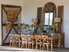 a wooden table topped with lots of vases filled with flowers next to a mirror