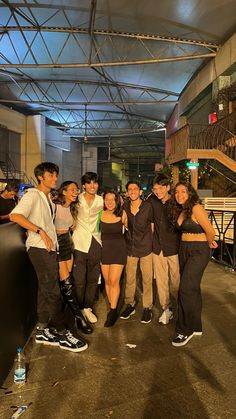 a group of young people standing next to each other in front of a metal structure