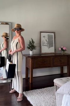 a woman standing in front of a mirror holding shopping bags