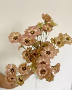 a person holding a vase with flowers in it