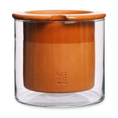 an orange candle in a glass jar on a white background with the words, wet hot candles