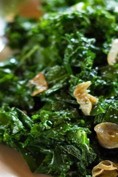 a white plate topped with greens and mushrooms