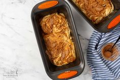 two pans filled with bread sitting on top of a counter next to each other