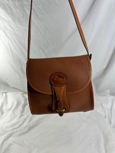 Measurements are 8" wide, 7"5 high, 3"5 deep with a 51" adjustable shoulder strap with a 22" drop. There is one main compartment, 2 back pockets, back zipper pocket, solid brass hardware, one exterior pocket  for easy to access items and front flap closure. This lovely bag is made of tan leather along with brass hardware. There are some scuffs  with no tears and a few very light ink scuffs interior.  This lovely Dooney & Bourke bag can be used cross body, comes with serial# A4 777646, guarantee Dooney & Bourke Bag, Dooney Bourke Handbags, Dooney Bourke, Leather Crossbody Bag, Leather Working, Zipper Pocket, Tan Leather, Leather Crossbody, Purses And Handbags