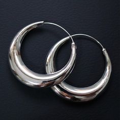 Elevate your elegance with our 40 mm Crescent Hoop Earrings. Crafted from high-quality sterling silver, these striking hoops feature a sleek crescent design that adds a modern twist to a timeless classic. The 40 mm diameter offers a bold yet sophisticated statement, perfect for any fashion-forward individual. The smooth, polished finish of these earrings reflects light beautifully, enhancing your natural glow and adding a touch of glamour to your ensemble. Lightweight and comfortable, they are d Hoop Earrings Large, Sterling Silver Hoop Earrings, Sterling Silver Hoops, Natural Glow, Jewelry Earrings Hoops, Silver Hoops, Silver Hoop Earrings, Crescent Moon, Timeless Classic