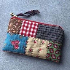 a small patchwork wallet is laying on the ground