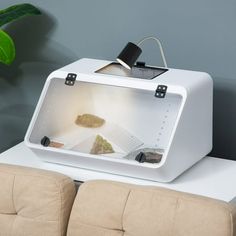 a white box with some rocks in it sitting on a table next to a couch