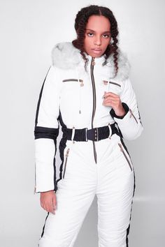 This women's jumpsuit is the perfect piece for those cold winter days. Made from rainwear, matte, waterproof fabric and insulated with polyester filler, this fitted white snowsuit was made to take on the cold. Its super cute and understated silhouette takes this minimal, jumpsuit to another level. The zipper closure, contrasting side stripes, and elasticized belt add just the right amount of details to this timeless apparel. The ski suit has also a hood trimmed with fur. Choose your size from th White Outerwear For Snowboarding Ski Season, White Outerwear For Snowboarding In Ski Season, White Outerwear For Snowboarding And Ski Season, White Skiing Outerwear For Winter, White Fitted Ski Season Outerwear, Fitted White Skiing Outerwear, White Fitted Skiing Outerwear, White Snowsuit, Minimal Jumpsuit