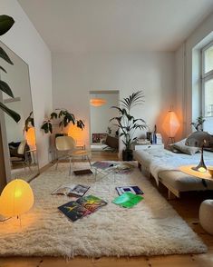 a living room filled with lots of furniture and plants on top of a white rug