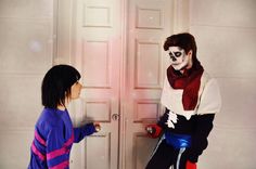 two children dressed up in costumes standing next to each other with their hands on the door knobs