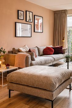 a living room filled with furniture and pictures on the wall above it's windows