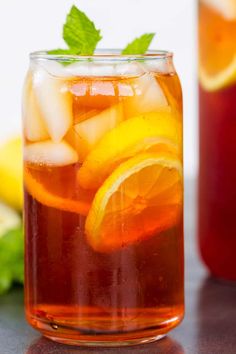 a glass full of iced tea with orange slices and mint