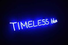 a neon sign that reads,'timeless blue'in white letters on a dark background