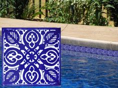 a blue and white tile sitting on the side of a swimming pool