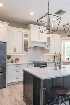 a kitchen with white cabinets and an island