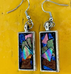 Add to touch of elegance to your look with our handmade, rainbow holographic rectangular earrings. These earrings feature silver pendants with vibrant colors, including blue, pink, gold and bronze. The mesmerizing holographic effect create a unique, one-of-a-kind look that will set you apart. These earrings also make an excellent gift for those who appreciate distinctive handcrafted jewelry. Modern Multicolor Rectangular Jewelry, Rectangular Rainbow Jewelry For Gifts, Modern Handmade Rainbow Jewelry, Nickel-free Multicolor Rectangular Earrings, Square Multicolor Earrings For Gift, Multicolor Rectangular Earrings As A Gift, Multicolor Rectangular Earrings For Gifts, Nickel-free Rectangular Pendant Earrings As Gift, Nickel Free Rectangular Pendant Earrings As Gift