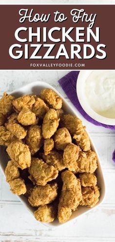 chicken gizzards in a white bowl with yogurt on the side and text overlay that reads how to fry chicken gizzands