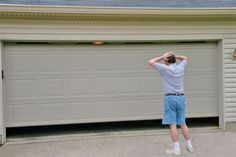 a man standing in front of a garage with his hands on his head and looking up