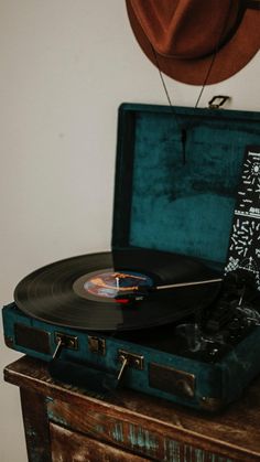 an old record player sitting on top of a suitcase