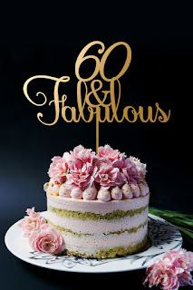 a cake with pink flowers on top and the word fabulous is spelled in gold lettering