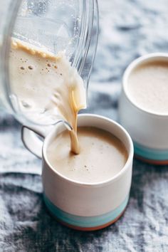 two cups filled with liquid sitting on top of a table