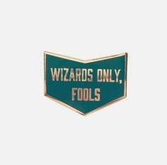 a green and gold pin with the words wizards only, fools