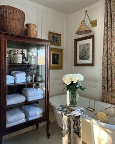 a bath room with a tub and a shelf filled with towels