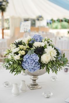 a vase filled with blue and white flowers on top of a table