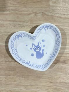 a blue and white heart shaped dish sitting on top of a wooden table