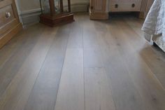 a bedroom with wooden floors and white walls