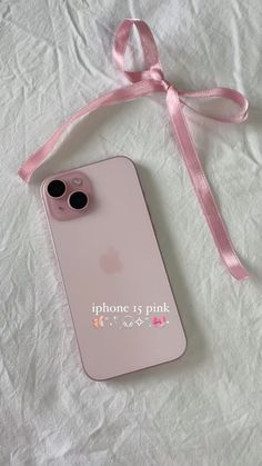 an iphone case with a pink ribbon attached to it on top of a white sheet