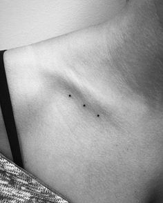 a black and white photo of a woman's stomach with small dots on it