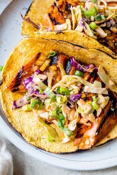 two tacos on a plate with cole slaw