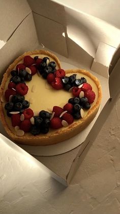 a heart shaped cheesecake with berries and blueberries