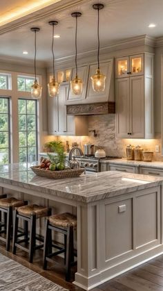 a large kitchen with an island and lots of lights hanging from the ceiling above it