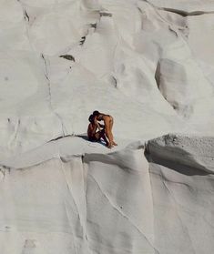 a man climbing up the side of a snow covered mountain