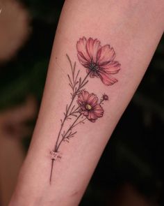 a tattoo with pink flowers on the arm