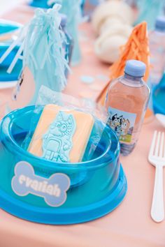 a table set up with plates, cups and utensils for a dog themed birthday party