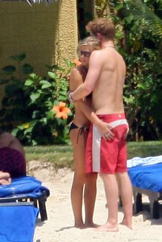 a man and woman embracing on the beach