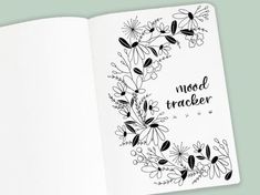 an open book with black and white flowers on the cover that says mood trackerr