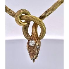 This is part of Chairish’s Fine Jewelry assortment.  This piece is from the early 1900's and is very special as it is longer than most snake necklaces. Women were much smaller then, so most are 13" to 15" necklaces.  This necklace is 16" plus the drop for the snakes head. Perfect for most women. This snake has a beautiful carved and detailed face with a 0.20 point Diamond on his head. This is marked 750 and weighs in at 24.62 grams of gold.  I just love snake jewelry as many of you now but seldom do I purchase these snake necklaces because they are too small for most.  Unless they are 16" or better I let them go.  This one fits the bill as it is 16" plus the drop for the snakes head. Vintage Yellow Gold Diamond Necklace For Formal Occasions, Vintage Gold Pendant Diamond Necklace, Vintage Gold Diamond Pendant Necklace, Gold Snake-shaped Engraved Necklace, Gold Snake Necklace With Engraving, Antique Gold Diamond Necklace For Formal Occasions, Gold Engraved Snake Necklace, Luxury Snake Shape Necklace For Formal Occasions, Luxury Formal Snake Shape Necklace