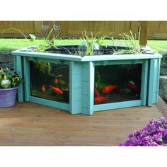 there is a fish tank in the middle of a deck with plants growing out of it