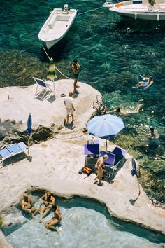 people are relaxing in the water near some boats