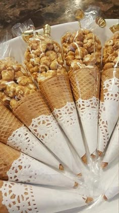 ice cream cones filled with nuts on top of a white plate in front of a counter