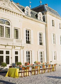 a large building with tables and chairs in front of it