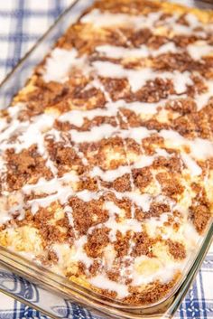 a casserole dish with white sauce and cinnamon crumbs on top, sitting on a blue checkered cloth