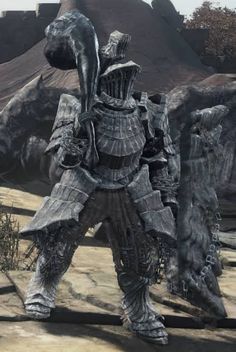 a man dressed in armor standing on top of a rock covered ground next to a mountain