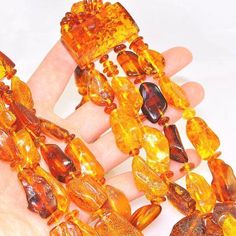 a hand holding several pieces of yellow glass beads