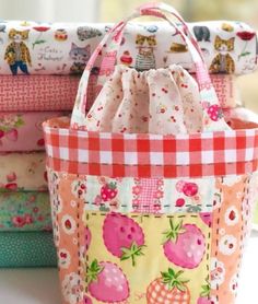 four bags are stacked on top of each other in different colors and patterns, one is pink