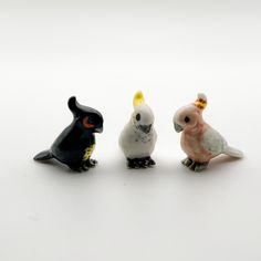 three small plastic birds sitting next to each other